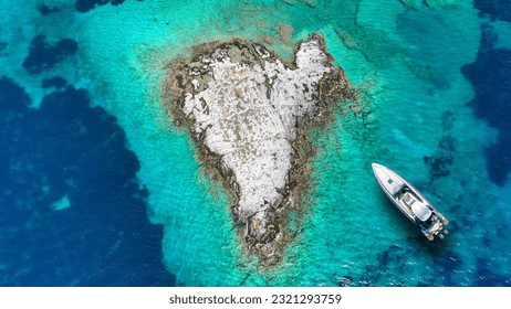 Aerial drone top down photo of inflatable rib anchored in heart shaped small islet of Plaka in Tsigouri beach, Schoinousa, Small Cyclades, Greece - Shutterstock ID 2321293759