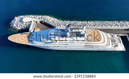 Aerial drone top down photo of luxury yacht with wooden deck and helipad anchored in tropical exotic island port