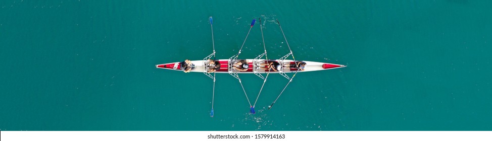 Aerial Drone Top Down Ultra Wide Panoramic View Of Sport Canoe Rowing Synchronous Athletes Competing In Tropical Exotic Lake