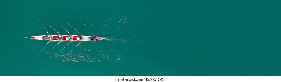 Aerial drone top down ultra wide panoramic view of sport canoe rowing synchronous athletes competing in tropical exotic lake - Shutterstock ID 1579914190