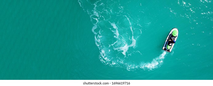 Aerial drone top down ultra wide photo of jet ski watercraft cruising in low speed in tropical exotic lake with calm emerald waters - Powered by Shutterstock