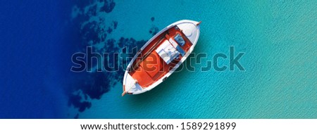 Aerial drone top down ultra wide photo of traditional wooden fishing boat docked in paradise beach of Elafonisos island, Peloponnese, Greece