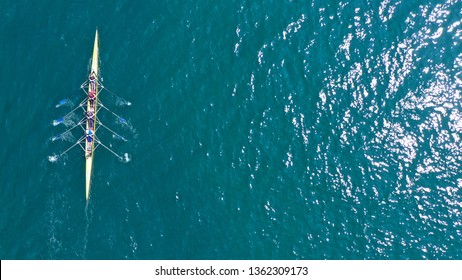 Aerial drone top down  view photo of yellow sport canoe operated by team of young women in emerald clear sea - Shutterstock ID 1362309173