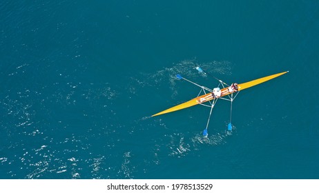 Aerial drone top down view of sport canoe operated by team of young trained athletes in deep blue Aegean sea - Shutterstock ID 1978513529