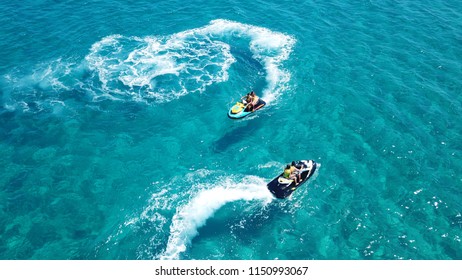Aerial drone top view of 2 couple on jet ski watercraft manoeuvring in tropical turquoise clear sea