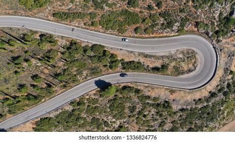 Aerial drone top view photo of curve snake road on a steep mountain slope leaving from Delphi village to Itea, Greece