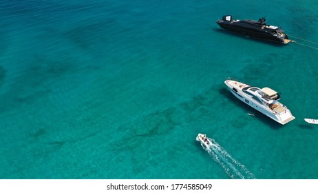 Aerial Drone Top View Photo Of Large Black Yacht - Boat With Wooden Deck Anchored In Tropical Exotic Paradise With Turquoise Open Sea