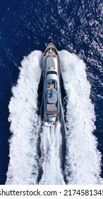 Aerial Drone Top View Photo Of Beautiful Modern Super Yacht With Wooden Deck Cruising In High Speed Deep Blue Aegean Sea