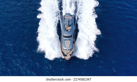 Aerial Drone Top View Photo Of Beautiful Modern Super Yacht With Wooden Deck Cruising In High Speed Deep Blue Aegean Sea