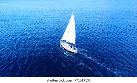 Aerial Drone Top View Photo Of Sail Boat With White Sails, Sailing In Mediterranean Aegean Island Of Santorini, Cyclades, Greece