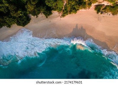 Aerial drone top view shot of rocky beach with cliff. Indian ocean shore. Copy space for text. Nature and travel background. Beautiful natural summer vacation travel concept. Waves and sand.