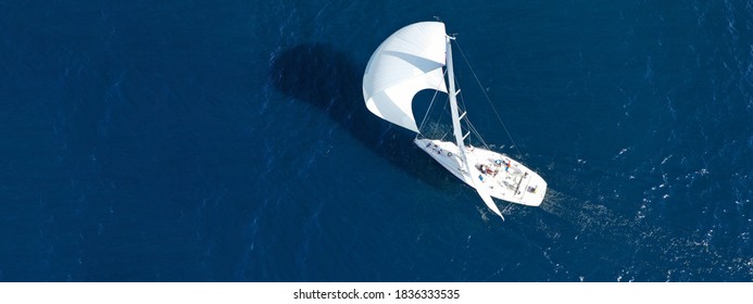 Aerial drone ultra wide panoramic photo of beautiful sailboat with white sails cruising deep blue sea near Mediterranean destination port - Shutterstock ID 1836333535