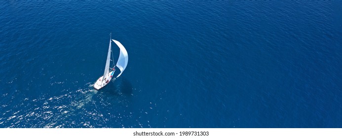Aerial drone ultra wide panoramic photo of beautiful sail boat with white sails cruising deep blue sea near Mediterranean destination port - Shutterstock ID 1989731303