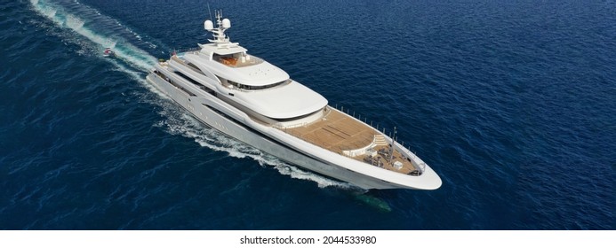 Aerial drone ultra wide panoramic photo of beautiful modern super yacht with wooden deck cruising in high speed deep blue open ocean sea - Shutterstock ID 2044533980