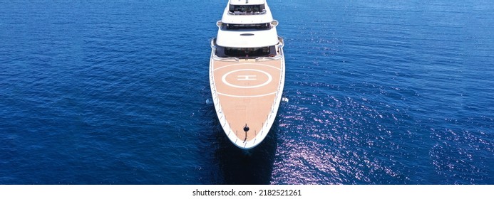 Aerial Drone Ultra Wide Panoramic Photo With Copy Space Of Bow From Mega Luxurious Yacht With Wooden Deck Anchored In Aegean Island Deep Blue Sea