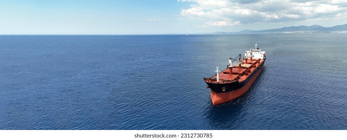 Aerial drone ultra wide panoramic photo with copy space of huge industrial bulk carrier tanker anchored in deep blue Aegean sea