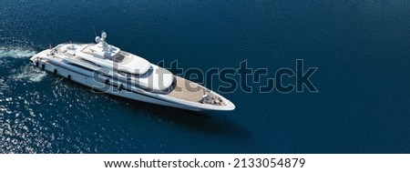 Aerial drone ultra wide panoramic photo of luxury yacht with wooden deck anchored in Mediterranean open ocean deep blue bay