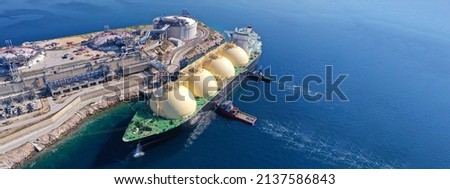 Aerial drone ultra wide panoramic photo with copy space of LNG (Liquified Natural Gas) tanker anchored in small gas terminal island with tanks for storage