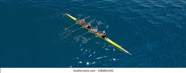 Aerial drone ultra wide photo of team of fit women practising in sport canoe in deep blue open ocean sea - Powered by Shutterstock