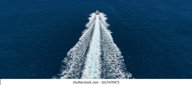 Aerial drone ultra wide photo of inflatable rigid power boat cruising in high speed in Mediterranean deep blue sea bay