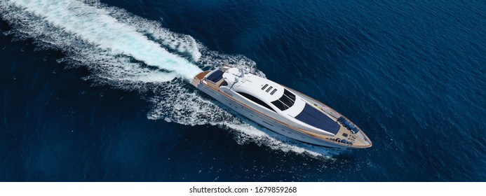Aerial drone ultra wide photo of luxury yacht cruising in deep blue sea near Mediterranean Aegean island