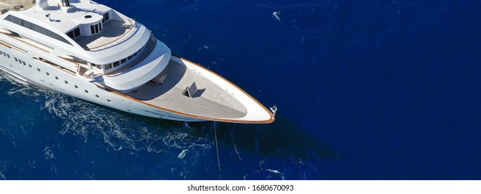 Aerial drone ultra wide photo of luxury mega yacht with wooden deck anchored in deep blue sea of Mykonos island, Cyclades, Greece - Shutterstock ID 1680670093