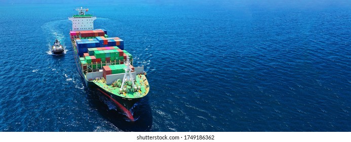Aerial drone ultra wide photo of fully loaded container cargo ship cruising in open ocean deep blue sea