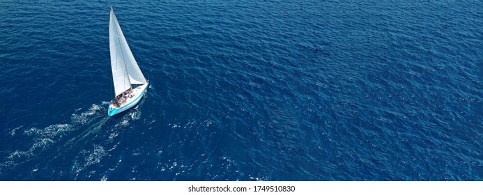 Aerial drone ultra wide photo of beautiful sail boat with white sails  sailing open ocean deep blue sea