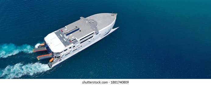 Aerial Drone Ultra Wide Photo Of High Speed Passenger Catamaran Ferry Approaching In Low Speed Iconic Port Of Piraeus, Attica, Greece