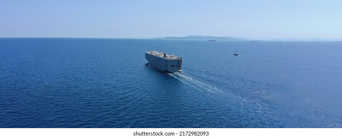 Aerial drone ultra wide photo with copy space of Large RoRo (Roll on-off) car cargo ship cruising the Mediterranean deep blue sea