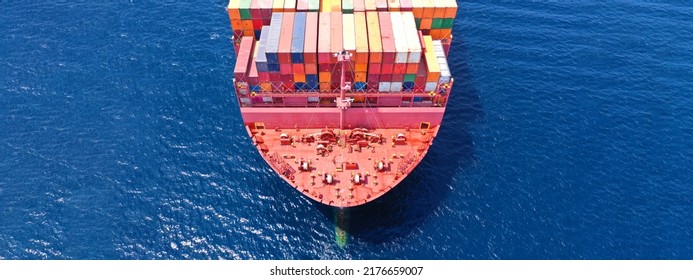 Aerial Drone Ultra Wide Photo Of Bow From Huge Fully Loaded Container Tanker Ship Carrying Truck Size Colourful Containers In Deep Blue Open Ocean Sea