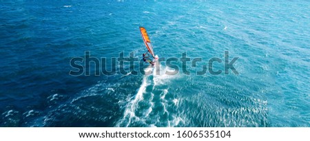 Aerial drone ultra wide photo of wind athlete surfer practising in deep blue open ocean sea
