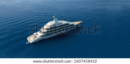Aerial drone ultra wide photo of luxury yacht with wooden deck anchored near port of Port of Fontvieille in deep blue sea, Monaco, France