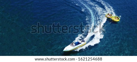 Aerial drone ultra wide photo of extreme powerboat donut water-sports cruising in high speed in tropical turquoise bay