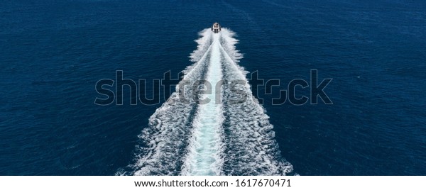 Aerial\
drone ultra wide photo of inflatable rigid power boat cruising in\
high speed in Mediterranean deep blue sea\
bay
