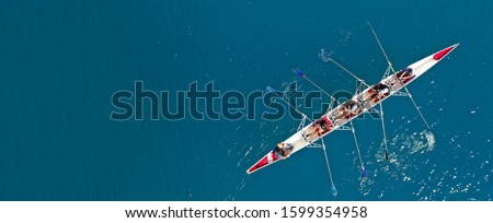 Aerial drone ultra wide top down photo of sport canoe with young team of athletes practising in deep blue open ocean sea