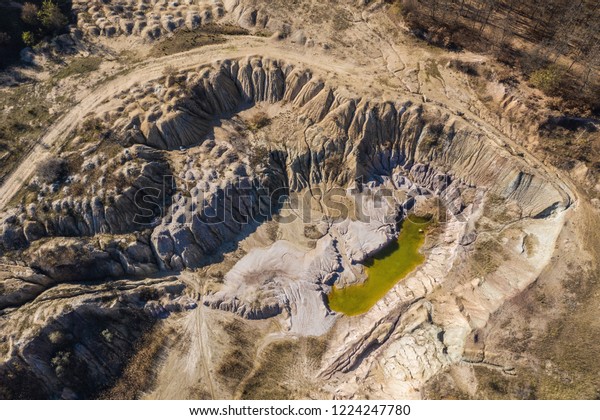 Aerial drone\
view of abandoned and flooded open pit gypsum mine, quarry.\
Polluted lake and mud. Industrial\
landscape