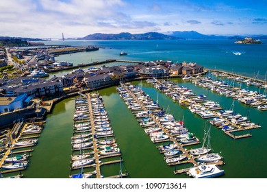 Aerial drone view above Bay Area Pier 39 and Docks , Sailboats , and yachts , with Alcatraz Island and San Francisco , California Golden Gate Bridge and entire Bay view