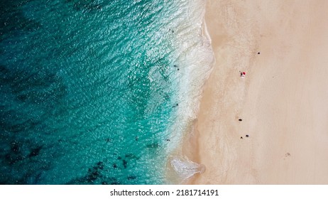 Aerial Drone View From Above Of A Beach With Turquoise Blue Water And A Few People Lying On The Beach During The Day In Oahu, Hawaii