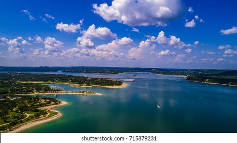 Aerial Drone View Above Lake Travis A Paradise Of Clear Blue Water And Relaxation Right Outside Austin Texas An Amazing Summer Landscape On The Lake With Boat Racing Across Water