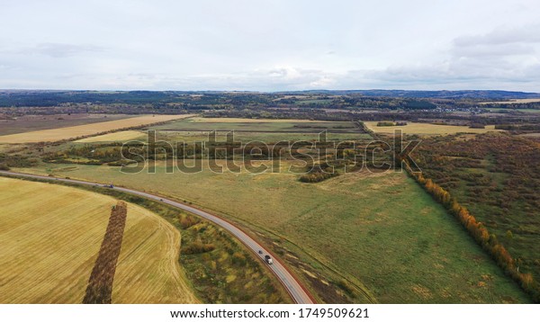 Aerial drone view\
agriculture crops wheat filed with road and cars. Highway road\
through field and meadow Landscape. Top View of cars In motion on\
road. Travel Trip\
Concept.