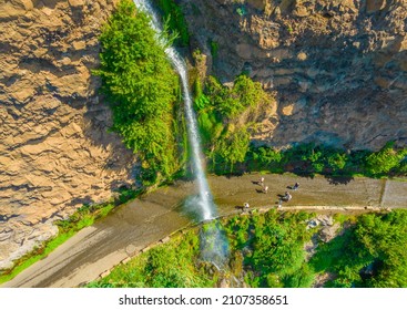 Aerial drone view of Angels waterfall (Cascata dos Anjos) in Madeira island. The waterfall cascades over the rockface onto the regional roadway, and spills into the sea below