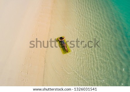 Aerial drone aerial view of Beautiful girl having fun on the sunny tropical beach. Seychelles 