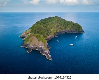 Aerial Drone View Of Boats Around A Remote, Mountains And Jungle Covered Tropical Island