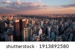 Aerial drone view of cityscape bathed in magic hour sunset light. Skyscrapers of landmark Avenida Paulista in major metropolitan city of Sao Paulo, Brazil.