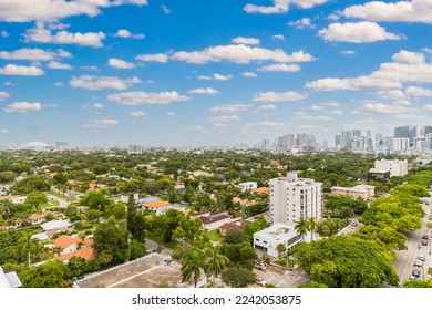 Aerial drone view of commercial area of Coral way neighborhood in Miami Beach, shops, street, palm trees, blue sky, buildings