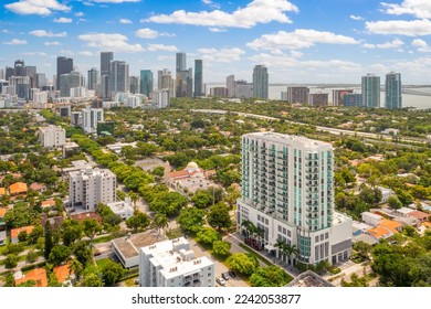 Aerial drone view of commercial area of Coral way neighborhood in Miami Beach, shops, street, palm trees, blue sky, buildings