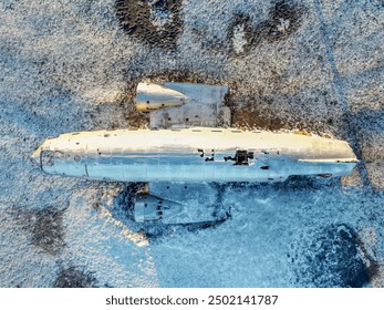 Aerial drone view of crashed plane on frozen Solheimasandur beach in winter, Iceland. Top view - Powered by Shutterstock