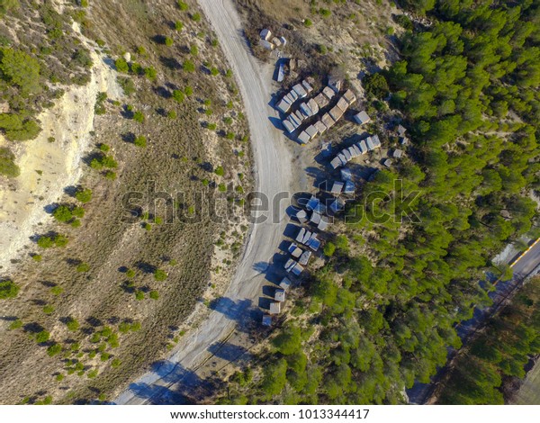 Aerial drone view of a curved road in a old quarry with\
stone squares 