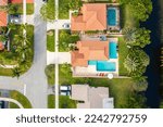 Aerial drone view of Deerfield Beach, luxury homes, mansions, green spaces, water channels, palms, trees, short grass, red roof tiles